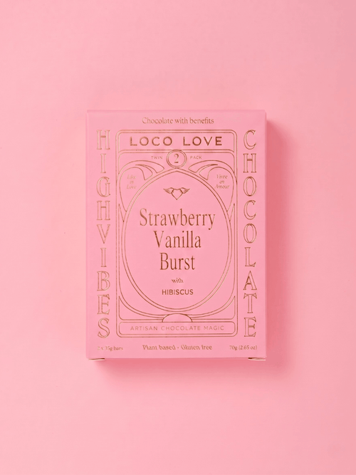 A pink rectangular box of Loco Love Chocolate with 'Strawberry Vanilla Burst' written in the center, photographed on a solid pink background.