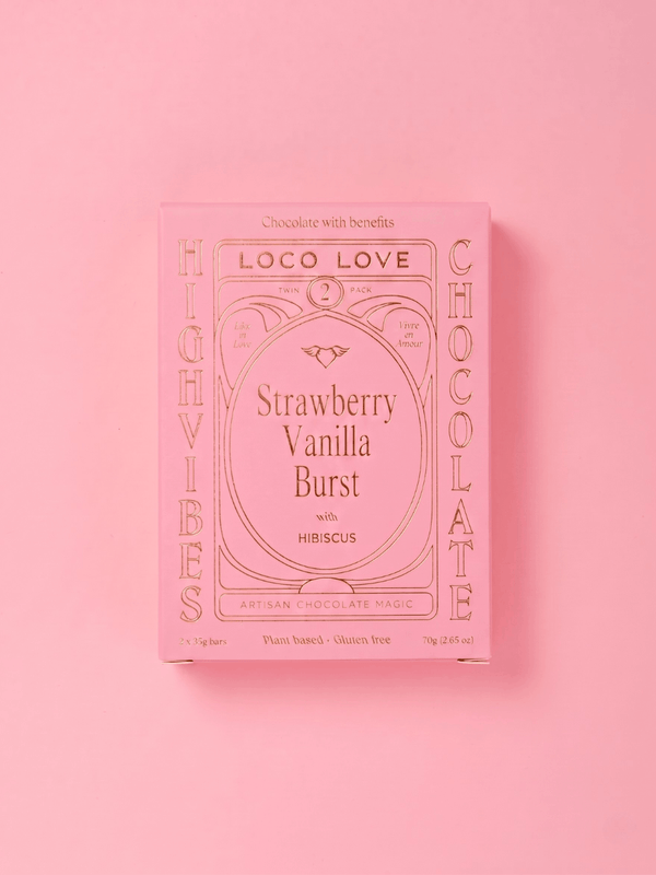 A pink rectangular box of Loco Love Chocolate with 'Strawberry Vanilla Burst' written in the center, photographed on a solid pink background.