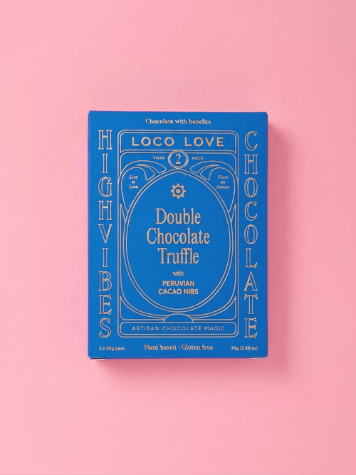 A blue rectangular box of Loco Love Double Chocolate Truffle with Peruvian Cacao Nibs, displayed on a solid pink background.
